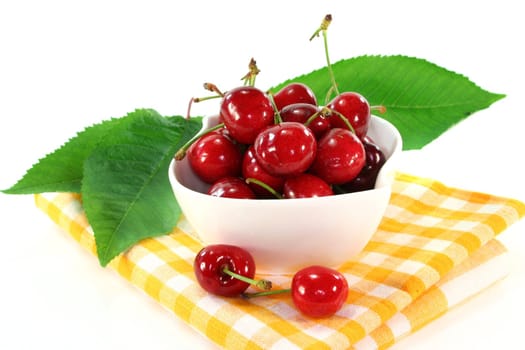 a white bowl filled with fresh cherries
