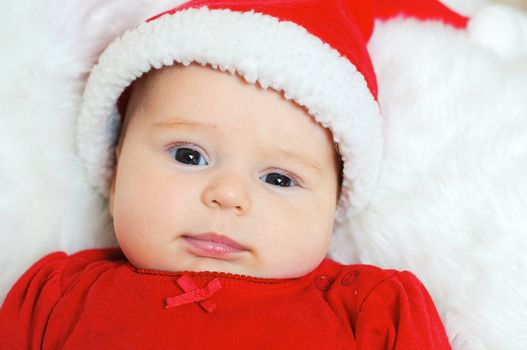 Surprised baby girl in santa claus hat