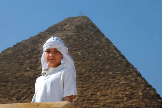 caucasian boy tourist portrait over pyramid in Egypt