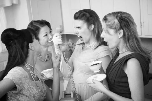 Angry woman on phone with three friends in a kitchen