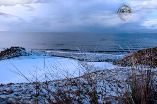 a snow covered links golf hole in ireland with blue flag and moonlit sky