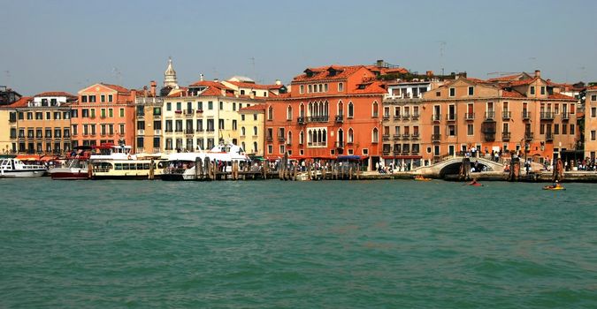 architecture of Venice, view from sea, boats and tourists by colorful buildings