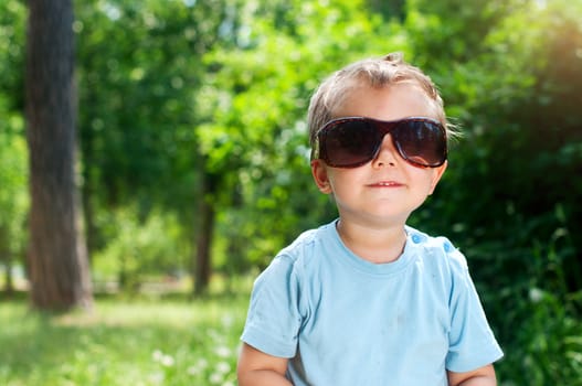 Cute 2 years old boy Sunglasses outdoors at sunny summer day