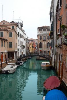 architecture of Venice, canal with parked boats and colorful buildings