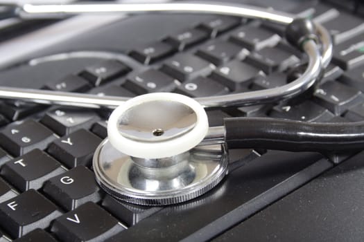 stethoscope on black keyboard of the computer