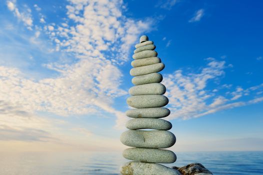 Balancing of white long pebbles on the seacoast