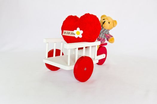 Red heart and bear on a tricycle.