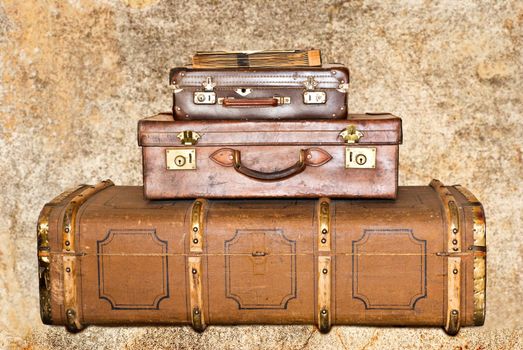 Three old leather suitcases on a grunge background