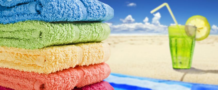 Colorful towels on a white with a cold drink