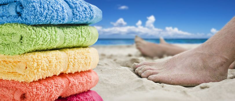 Colorful towels and bare feet on the beach