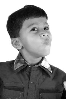 A black and white portrait of a cute Indian kid, on white studio background.