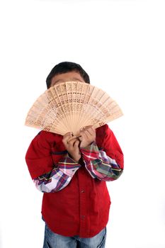 An Indian kid hiding his face behind a japanese fan, on white studio background.