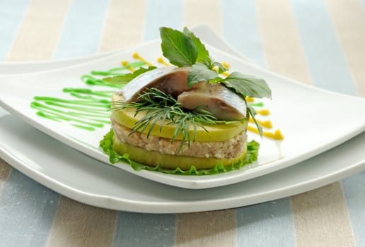 Appetizer of herring with apples with greens