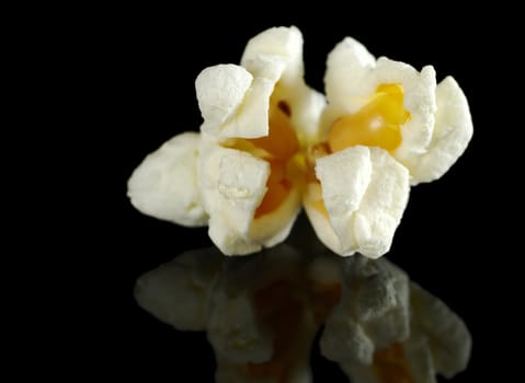 Macro shot of a single popcorn on black with reflection (Very Shallow Depth of Field, Focus on the front)