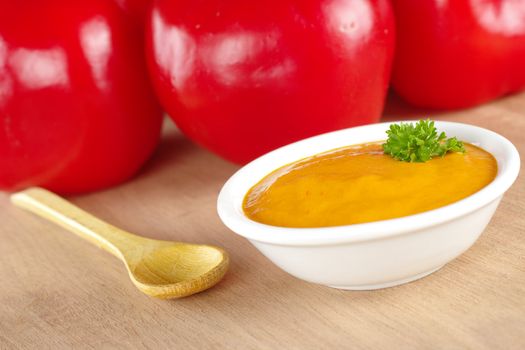 Peruvian hot salsa made of a red pepper called rocoto which is visible in the background (Selective Focus, Focus on the parsley)