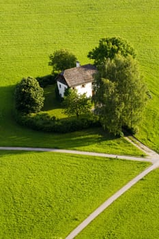 A Cottage in a meadow in summer with multiple paths