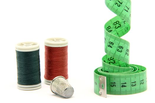 sewing items measure tape cotton strings and thimble isolated on white background