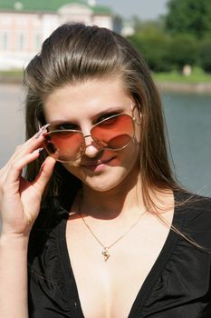 The beautiful woman in sunglasses on the nature