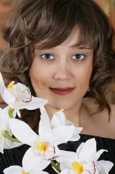 Portrait of the beautiful young woman with a white orchid