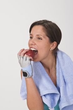 Beautiful young woman bitting a red apple.Shot with Canon 70-200mm f/2.8L IS USM