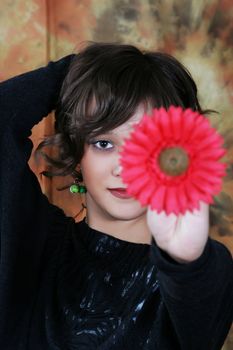 Portrait of the beautiful young woman with a red flower