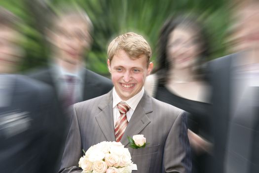 The joyful groom with a bouquet goes to the bride