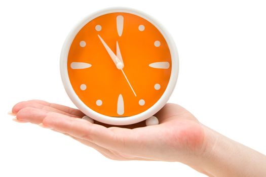 Woman holding an orange alarm clock. Isolated on a white background.