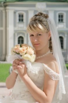 The fine bride on celebratory walk with a bouquet