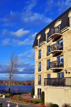 Luxury hotel or condo with wrought iron baclconies looking onto the lake on a beautiful sunny fall day.