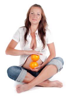 Beautiful pregnant with oranges woman in studio isolated on white