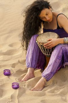 Woman outdoors enjoying the sunshine and playing her djembe