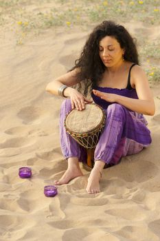 Woman outdoors enjoying the sunshine and playing her djembe