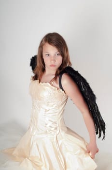 Teenager girl with black wings in studio