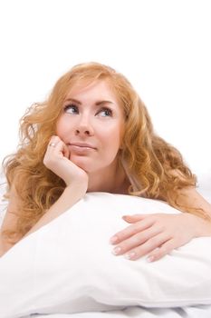 Redheaded woman on the pillow looking up