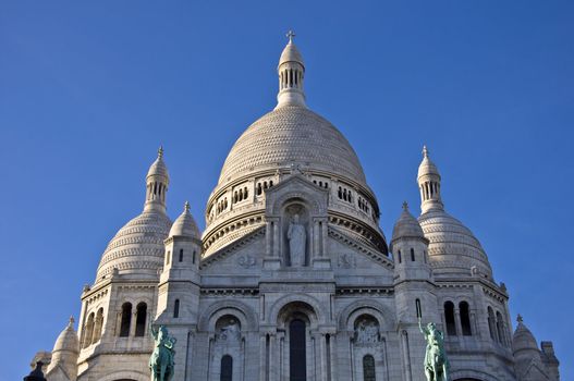 Basilica of Sacre Coeur in Paris. Against the blue clear sky. Urban scene.