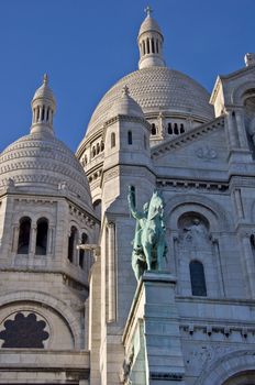 Basilica of Sacre Coeur in Paris. Against the blue clear sky. Urban scene.