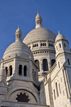 Basilica of Sacre Coeur in Paris. Against the blue clear sky. Urban scene.