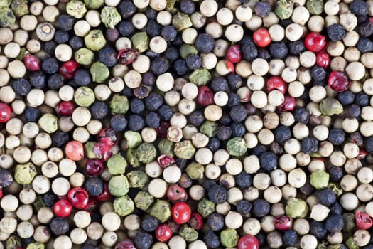 Mixture of white green red and black peppercorns as a food background or texture