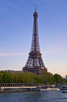 Eiffel Tower on the banks of the River Seine at sunset. Urban night landscape.