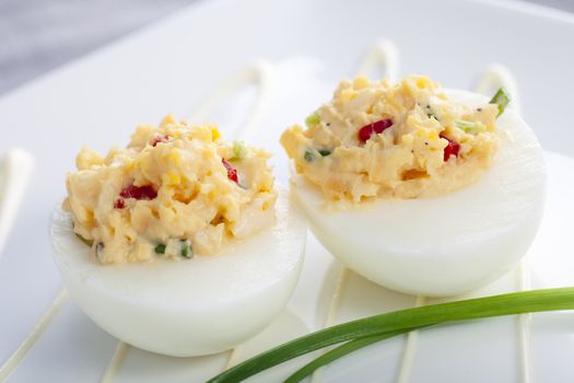 Two gourmet deviled eggs with chives garnish.