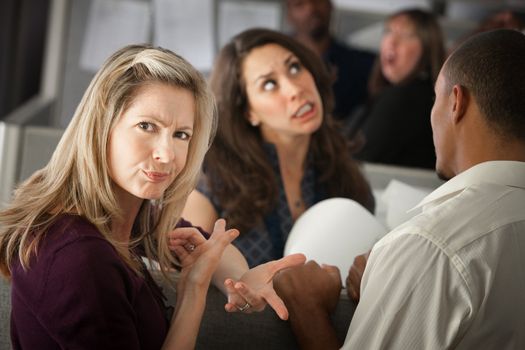 Annoyed woman with coworkers in office cubicle