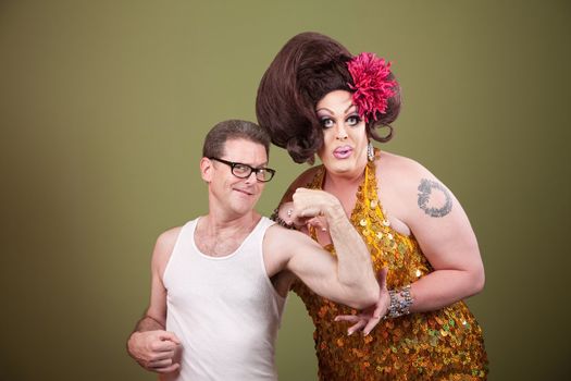 Man showing off bicep with large lady over green background