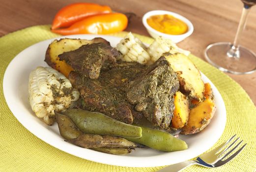 Traditional Peruvian food called Pachamanca which is from the Andean region. It consists of different kinds of meat covered with some herbs, broad beans (Spanish: habas), corn, potatoes and sweet potatoes. Traditionally it is cooked in the ground (Selective Focus, Focus on the beans and the front of the meat)