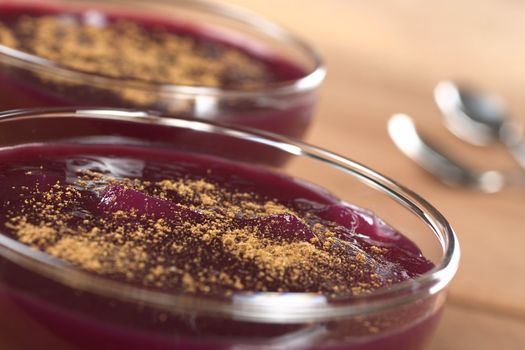 Popular Peruvian dessert called Mazamorra Morada, which is made from purple corn, fruits and spices and is garnished with cinnamon powder (Selective Focus, Focus on the middle of the first dessert)