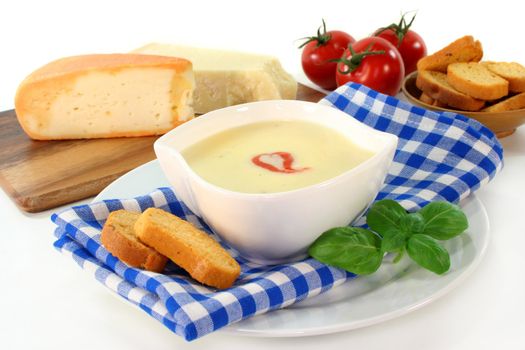 a bowl of cheese cream soup with croutons and basil