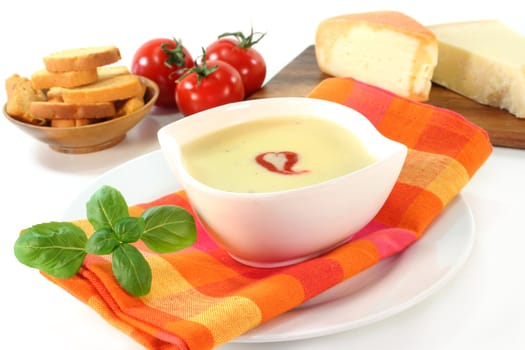 a bowl of cheese soup with croutons and basil
