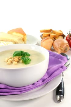 a bowl of cheese cream soup with croutons and basil