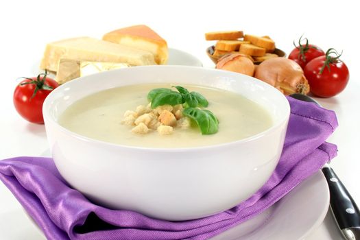 a bowl of cheese cream soup with croutons and basil