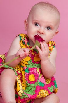 Beautiful baby girl eating flower