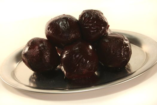 beetroot balls on a silver platter before a white background